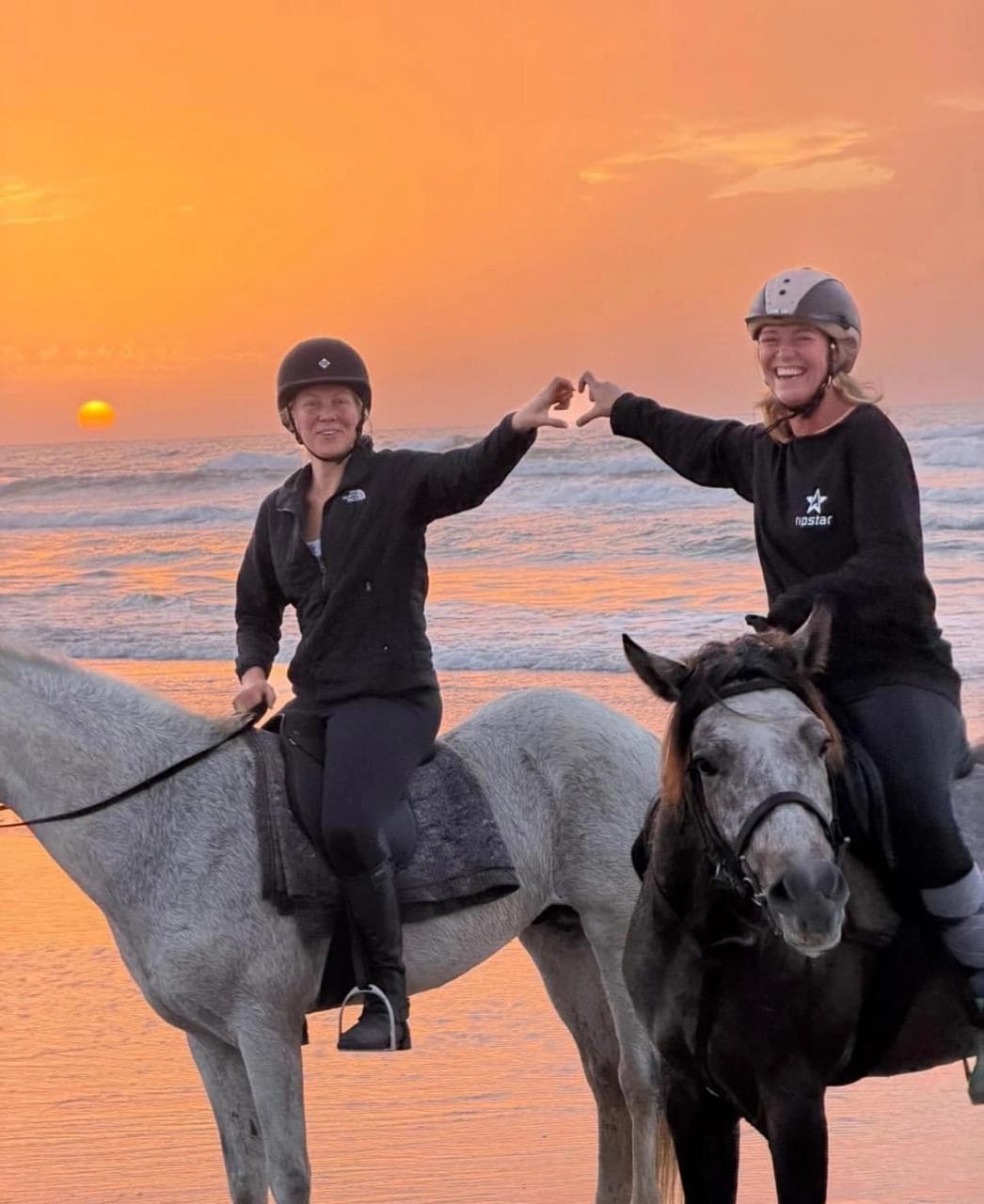 Horseback riding along the beach at sunset