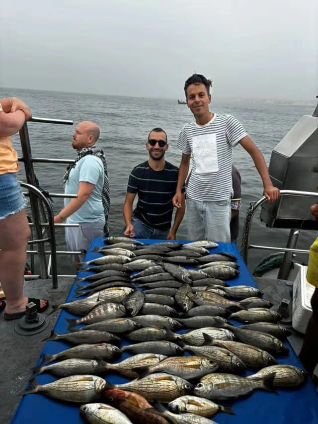 Guests standing beside a table covered with the day's catch