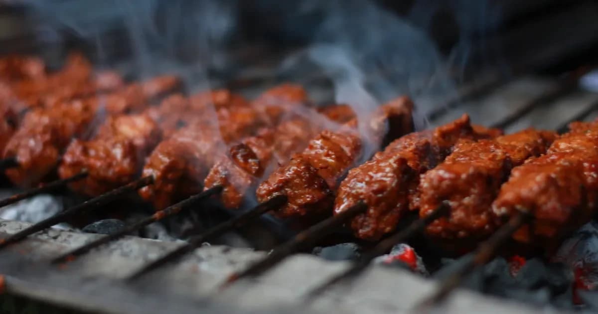 Grilled meat cooking over glowing coals
