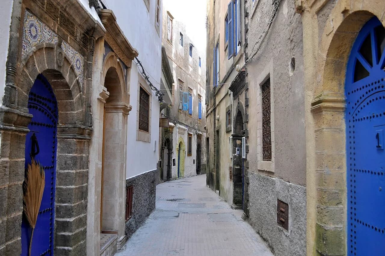 Whitewashed medina street with blue doors and shutters in Essaouira