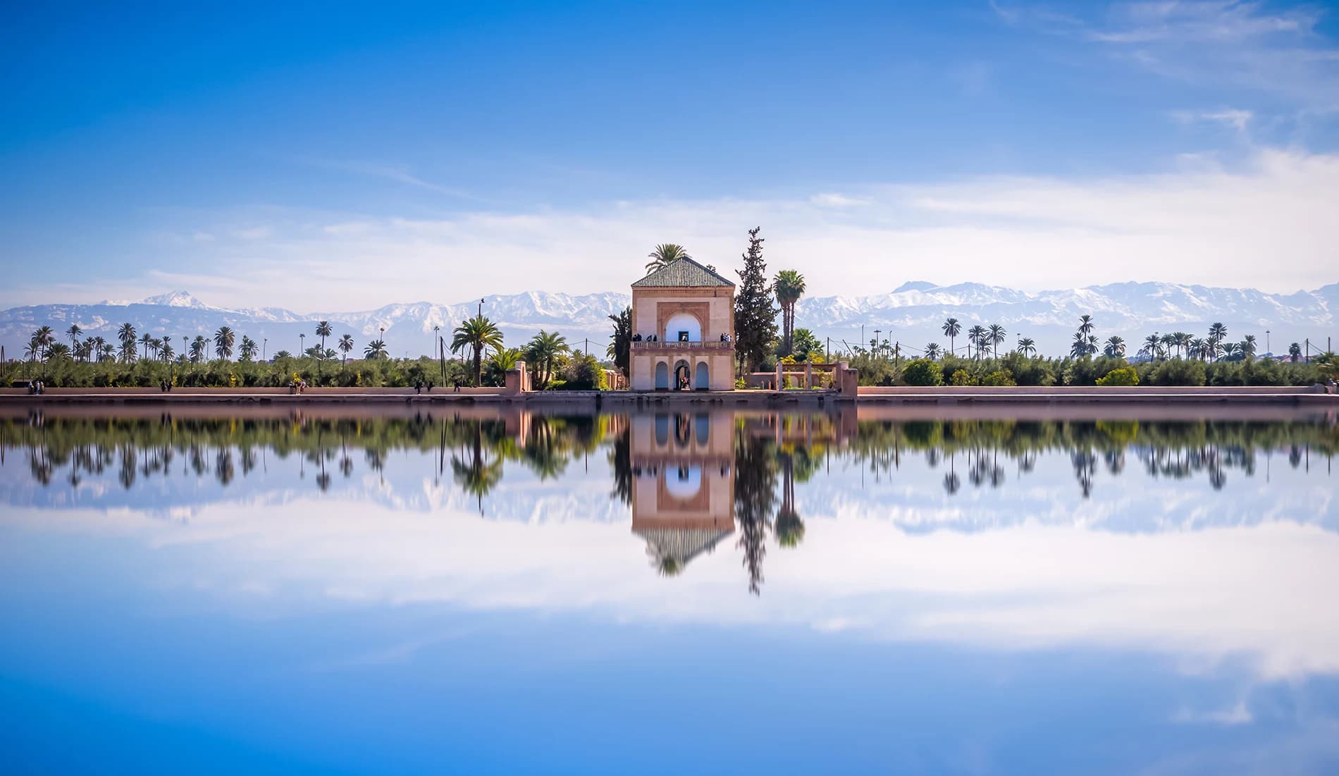 Menara Gardens pavilion reflected in its basin below the snow-capped Atlas Mountains